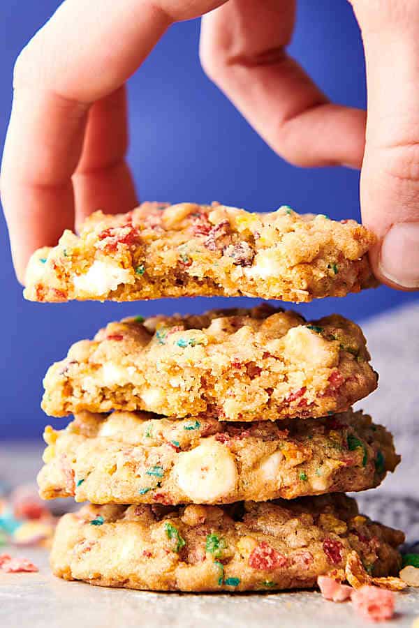 fruity pebbles cookies stacked, one being lifted off