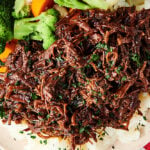 slow cooker flank steak over mashed potatoes with veggies above
