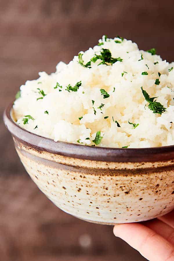 bowl of slow cooker rice held one hand