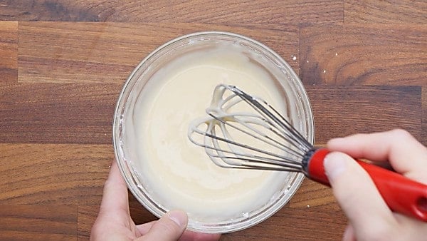 peach icing whisked in mixing bowl