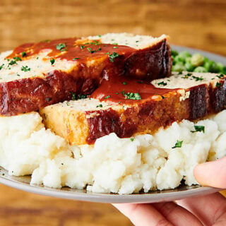 plate of chicken meatloaf on mashed potatoes held