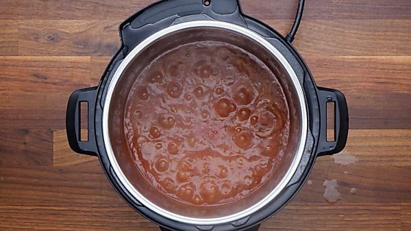 instant pot spaghetti sauce simmering with cornstarch slurry added