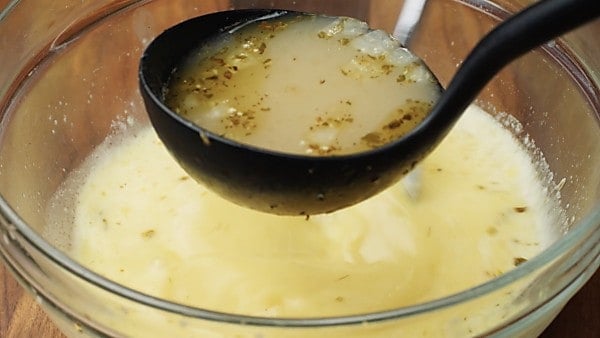 ladle of soup being added to lemon/egg