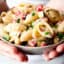 bowl of vegan pasta salad held two hands