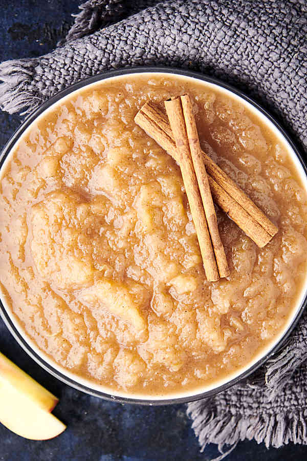 instant pot applesauce in a bowl with cinnamon sticks