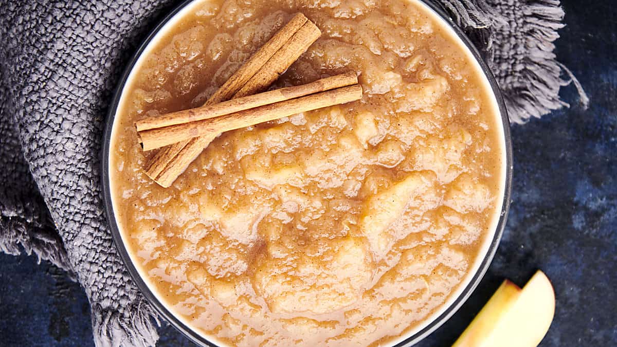 instant pot applesauce in a bowl with two cinnamon sticks