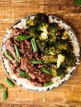 mongolian beef on a plate with rice and broccoli