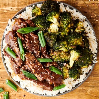 mongolian beef on a plate with rice and broccoli