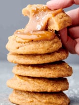 caramel cookie with a gooey caramel center stacked on top of other caramel cookies