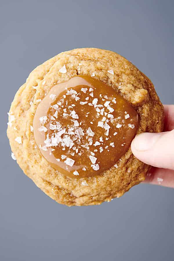 holding a caramel cookie with caramel filling