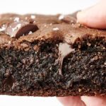 holding a flourless gluten free brownie with chocolate chips