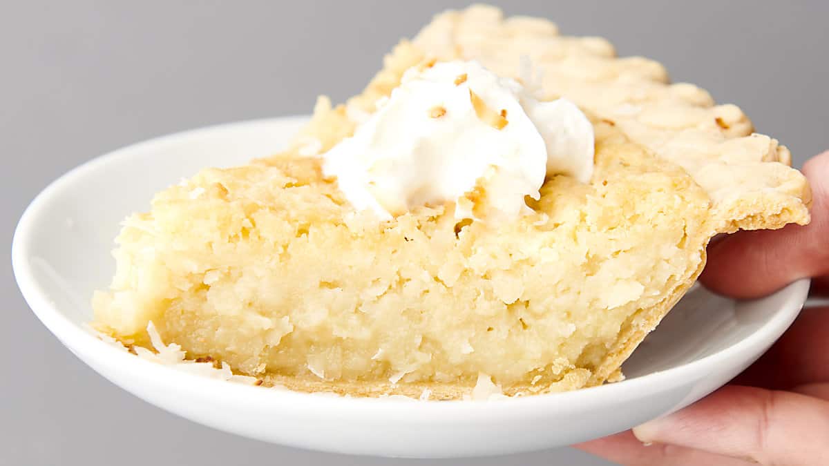 slice of coconut pie on a plate with whipped cream