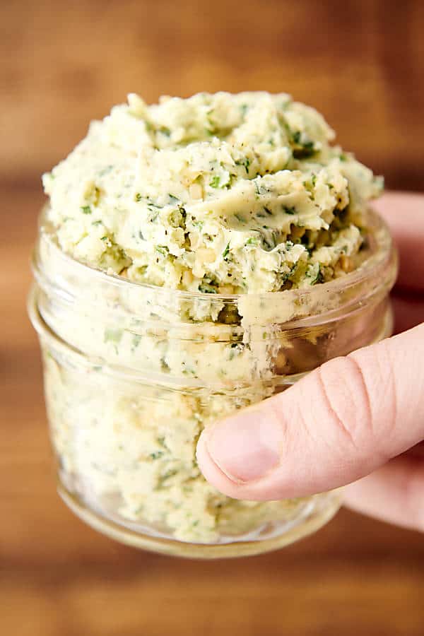 holding a jar of herb butter