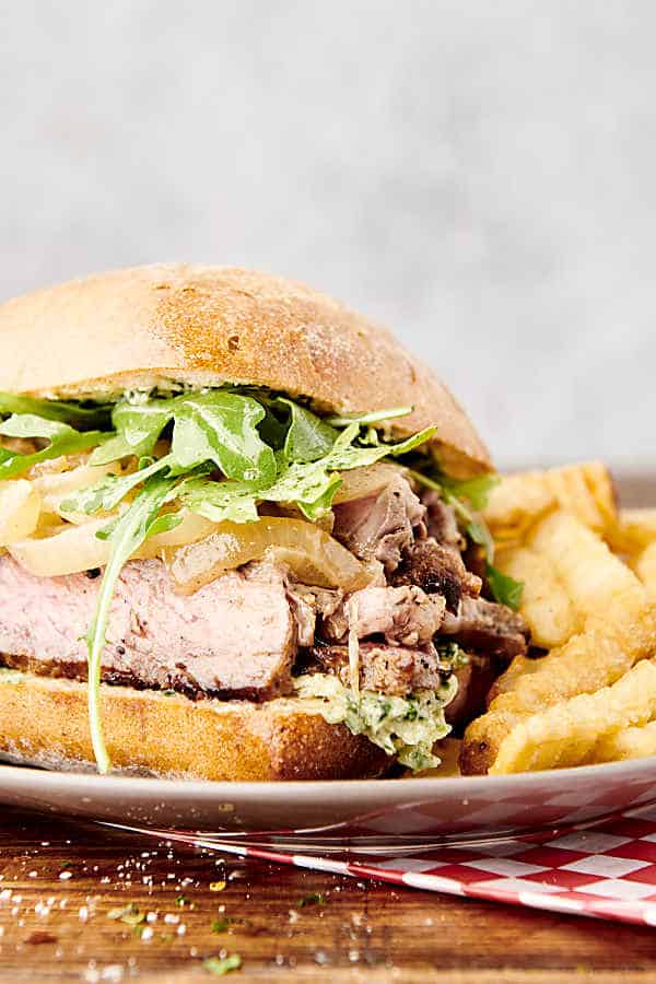 steak sandwich on a plate with french fries