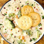 cheesy broccoli and potato soup topped with ritz crackers