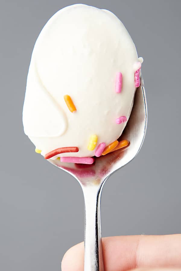 spoon of vanilla frosting with sprinkles