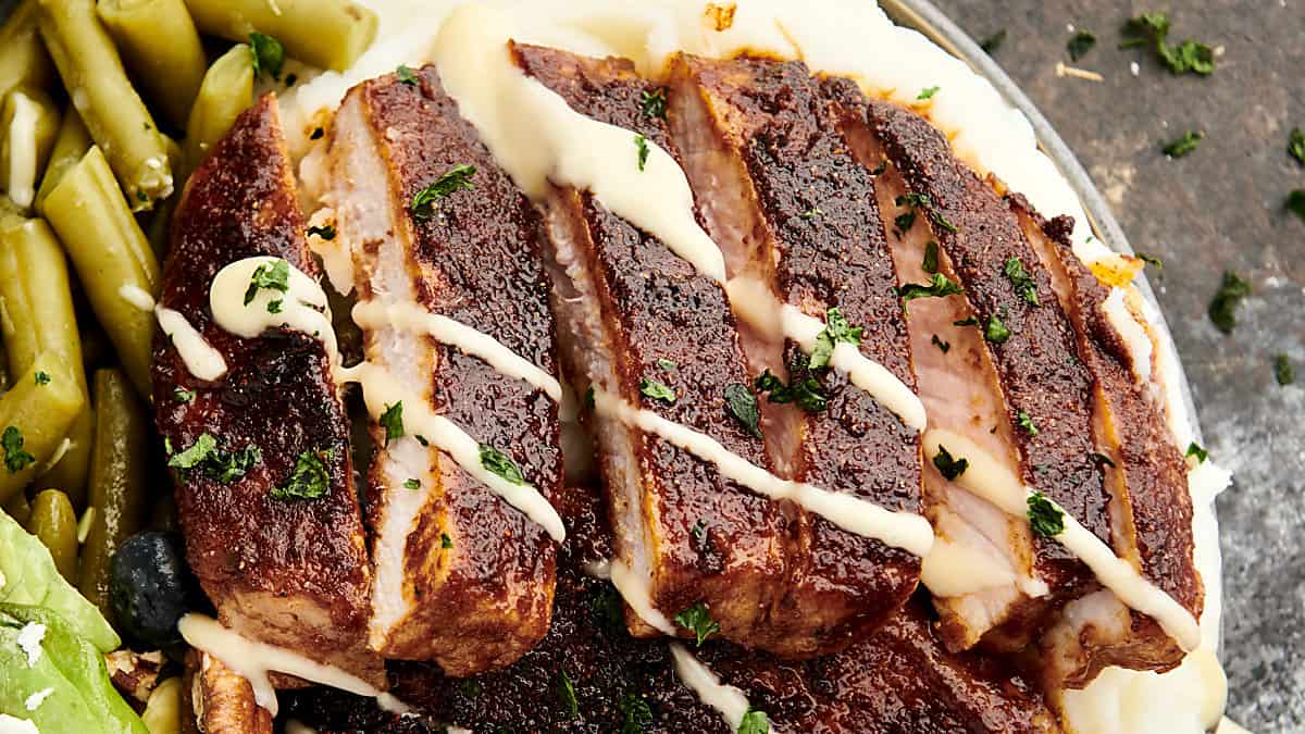 plate of sliced bbq pork chops drizzled with honey mustard