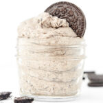 whipped oreo buttercream frosting in a glass jar topped with an oreo cookie
