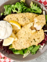 parmesan tilapia on a bed of greens