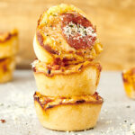stack of pizza cupcakes topped with pepperoni, parmesan, and red pepper flakes