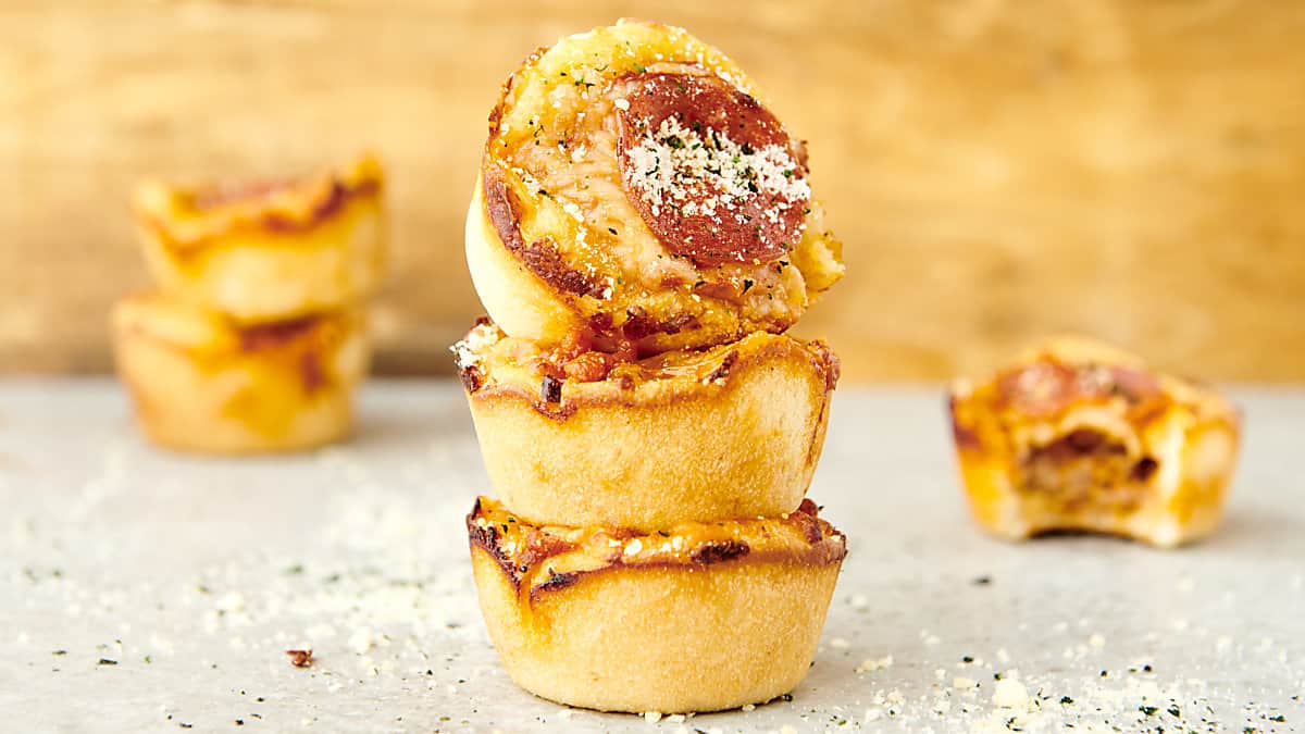 stack of pizza cupcakes topped with pepperoni, parmesan, and red pepper flakes