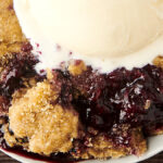 easy blueberry cobbler in a bowl with vanilla ice cream