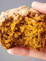 holding a pumpkin muffin with pecan streusel