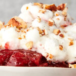bowl of cranberry jello salad with marshmallow topping
