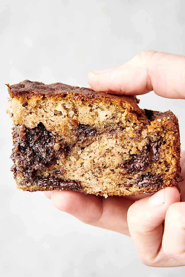 holding a piece of air fryer banana bread