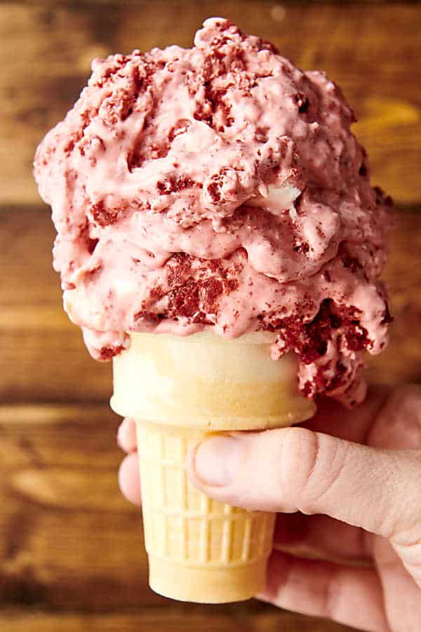 holding an ice cream cone with red velvet ice cream