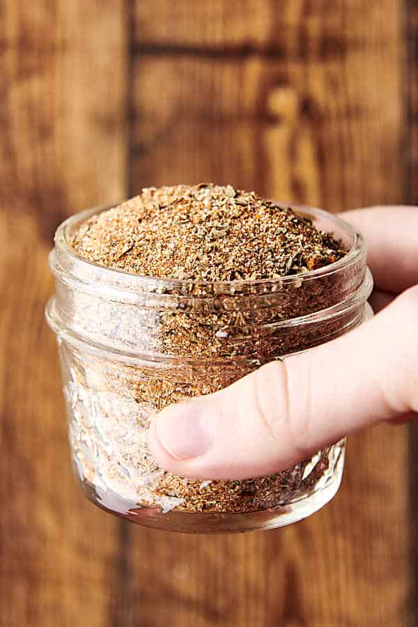 holding a glass jar of blackened seasoning