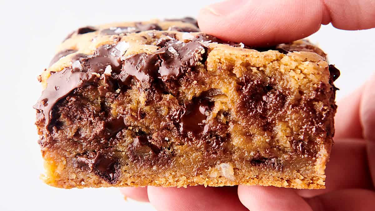 holding chocolate chip cookie bar in hand