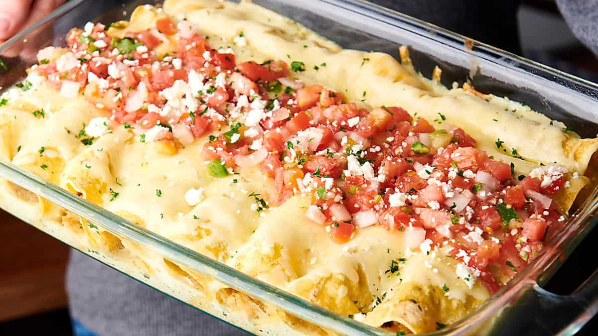 holding a pan of enchiladas suizas