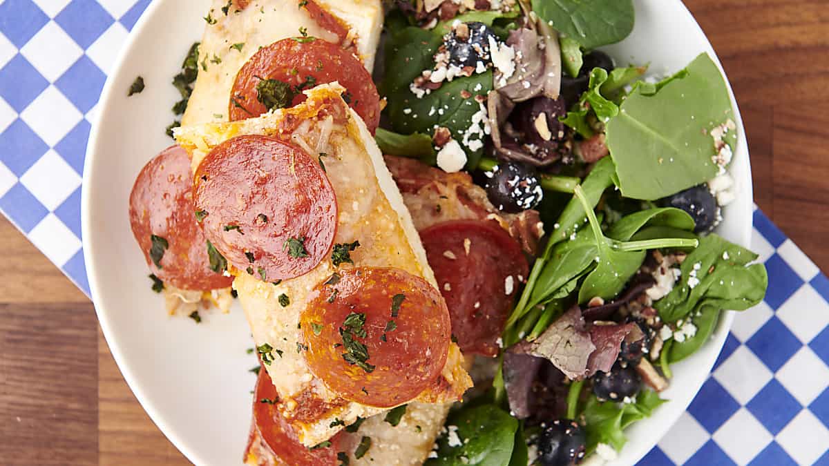 pepperoni french bread pizza on a plate with salad