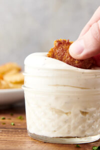 dunking chicken nugget into a jar of homemade ranch