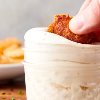 dunking chicken nugget into a jar of homemade ranch