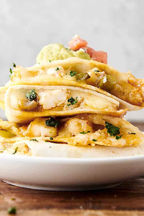 three stacked shrimp quesadillas on a plate