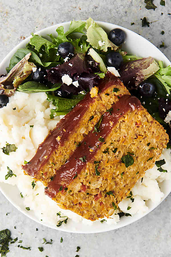 chickpea meatloaf on a plate with mashed potatoes and salad