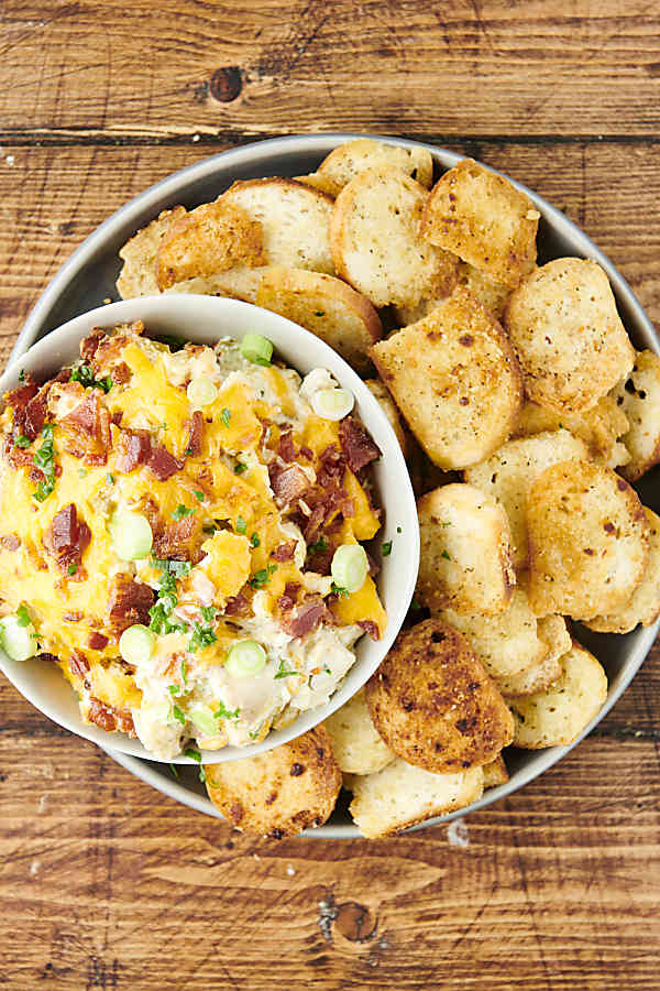bowl of chicken bacon ranch dip on a plate with bagel chips