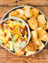 creamy chicken bacon ranch dip on a plate with homemade bagel chips