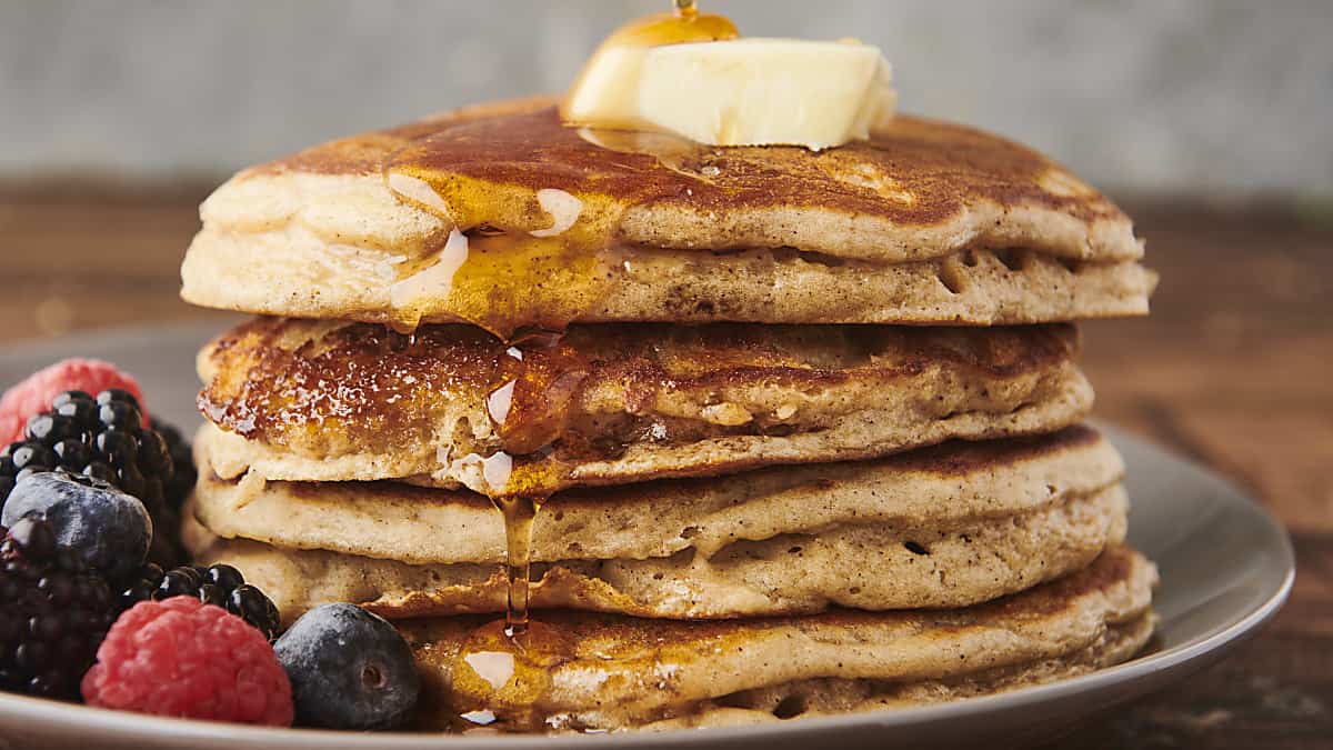 stack of diner style pancakes topped with butter and maple syrup