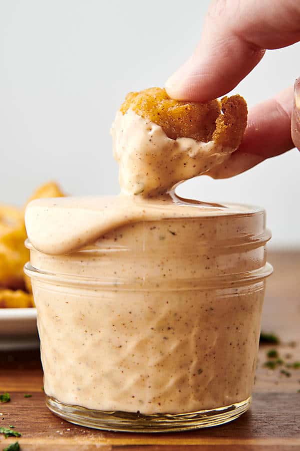 dipping chicken into spicy ranch