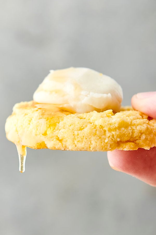 holding a cornbread cookie dripping with honey