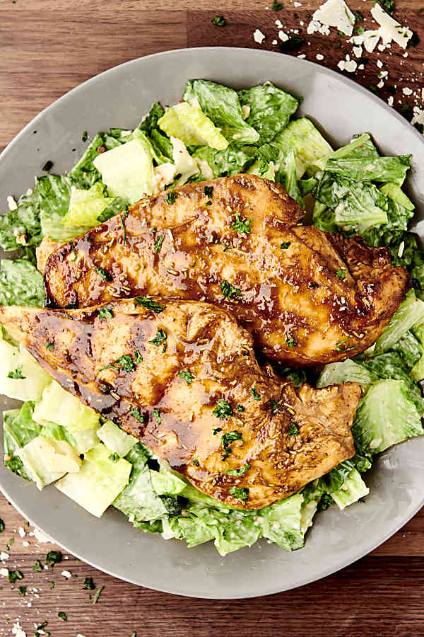 thinly sliced grilled chicken breasts on salad