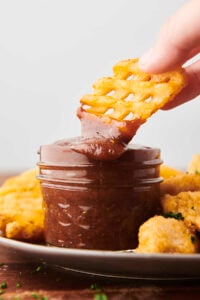Dunking a fry into barbecue sauce