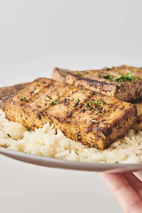 Holding a plate of tofu and rice