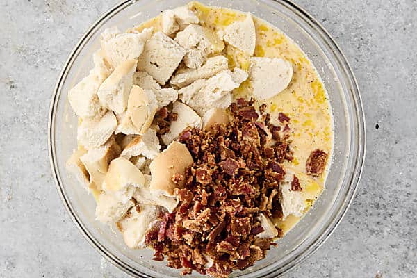 whisked eggs topped with bagels and crispy bacon