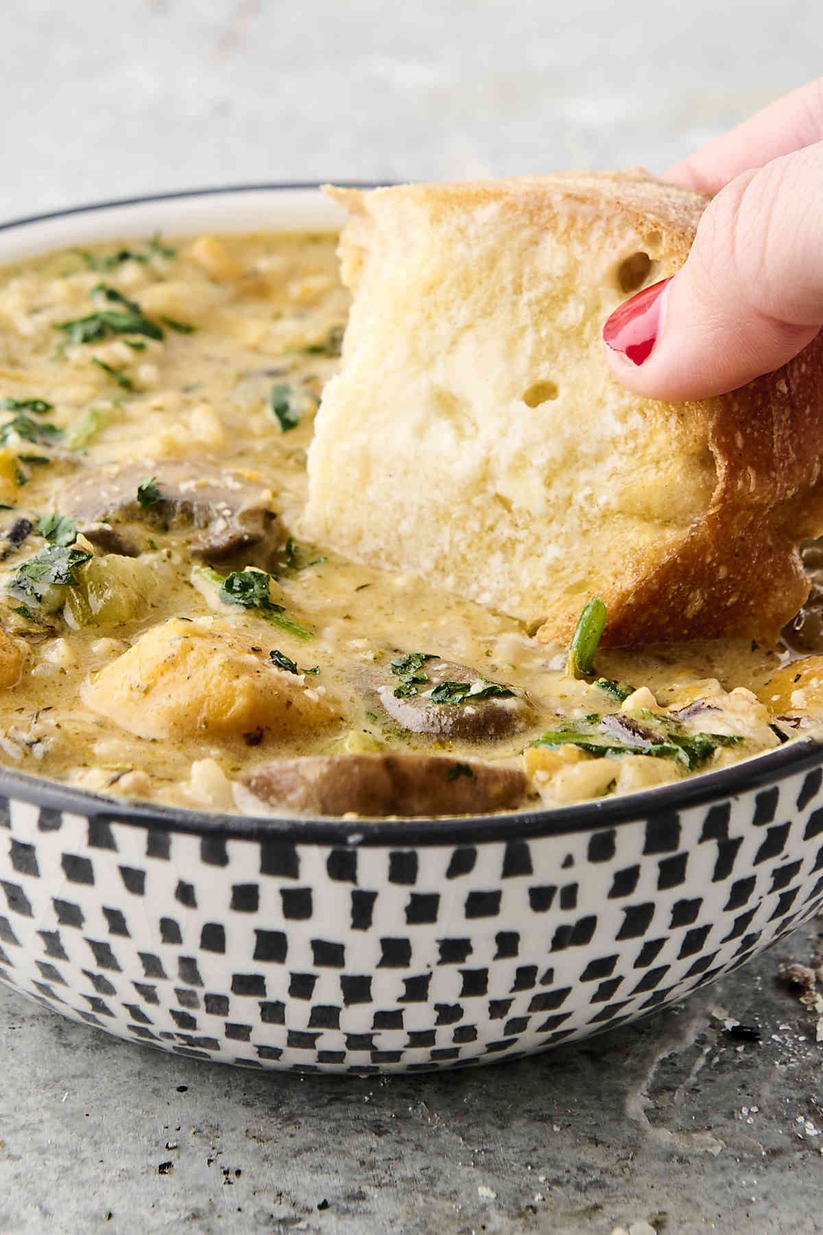 dunking bread into vegan wild rice soup