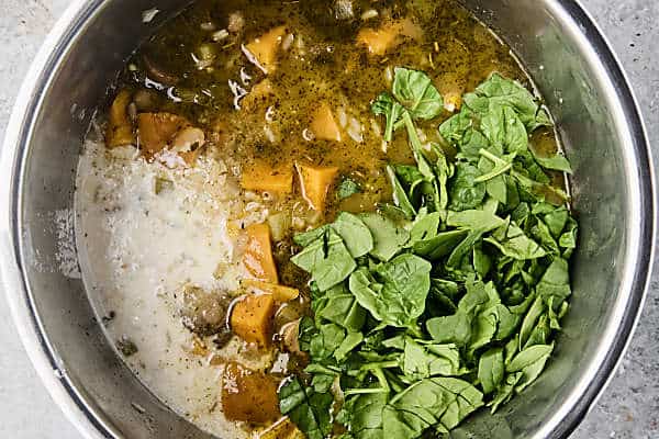 stirring coconut milk and spinach into soup