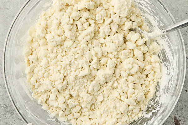 mixing together flour, baking powder, salt, and greek yogurt/cottage cheese to create a shaggy dough